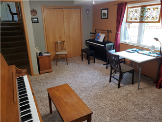 A room with a piano and chairs

Description automatically generated with medium confidence