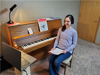 A person sitting at a piano

Description automatically generated with medium confidence